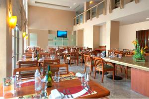 a restaurant with wooden tables and chairs and a bar at Fiesta Inn Poza Rica in Poza Rica de Hidalgo
