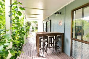a porch with a bar and stools on a deck at Tamarillo Bach - Coastal Comfort in Coopers Beach