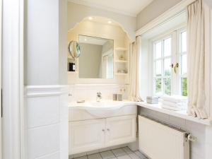 a white bathroom with a sink and a mirror at Hansenhoog-2 in Kampen