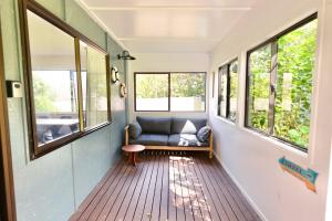 a living room with a couch and windows at Tamarillo Bach - Coastal Comfort in Coopers Beach +5 photos