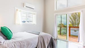 a white bedroom with a bed and a large window at Chateau Coho by AvantStay Easy Beach Access in Greenbank