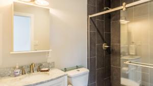a bathroom with a shower and a toilet and a sink at Chateau Coho by AvantStay Easy Beach Access in Greenbank +28 photos