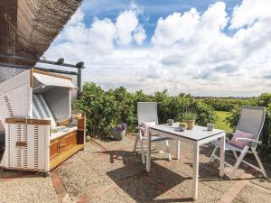 a patio with a table and two chairs and a television at Kliffsand-3 in Kampen