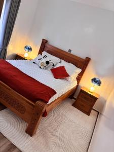 une chambre avec un lit en bois avec une couette rouge et blanche dans l'établissement Toshika Homes - Your Home Away from Home 2bedroom, à Tatu City