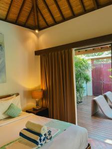 a bedroom with a bed and a large window at Pera ONE Villas in Gili Trawangan