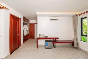 a room with a table and a bench and a closet at Flex Suites in Phum Pobos