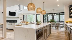an open kitchen and living room with pendant lights at Forget-Me-Not by AvantStay Bold Lakefront Escape in Monterey