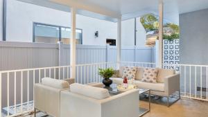 a living room with white chairs and a table at Fulton I by AvantStay Modern Haven in Downtown in Los Angeles