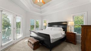 a bedroom with a large bed with white walls and windows at Lakefront 6BDR Priv Dock Game Room Firepit Jakes Lake House by Avantstay in Westport