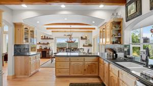 eine Küche mit Holzschränken und eine große Mittelinsel in der Unterkunft Hot Tub Fire Pit Game Room Amazing Deck Views Sky Canyon Lodge by AvantStay in Blue Jay