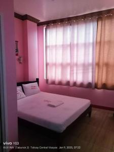 a small room with a bed with a window at Wjv Inn Tabunok ll in Talisay