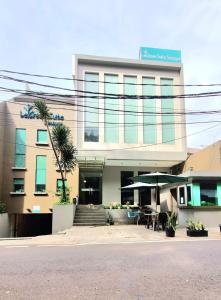 a building with a table and umbrella in front of it at LeGreen Suite Senayan in Jakarta