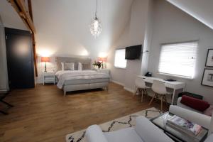 a bedroom with a bed and a living room at In de Witte Dame Hotel Bar Kitchen Apartments in Grubbenvorst