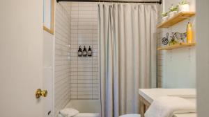 a bathroom with a shower curtain and a toilet at 2 Decks w Lake Glimpse Views Modern Luxe Cabin A-Frame Retreat by AvantStay in Lake Arrowhead +33 photos