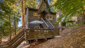 a tree house in the woods with an umbrella at 2 Decks w Lake Glimpse Views Modern Luxe Cabin A-Frame Retreat by AvantStay in Lake Arrowhead