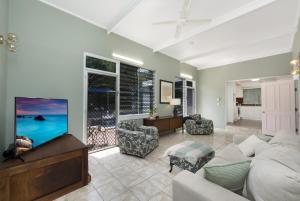 a living room with a couch and a flat screen tv at Island Holiday Memories in Nelly Bay in Nelly Bay