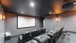 sala konferencyjna ze skórzanymi krzesłami i pustym ekranem w obiekcie Gray Fox Lodge by AvantStay WATERSLIDE Pool Theater Sleeps 23 w mieście Lake Norman of Catawba +74 zdjęcia