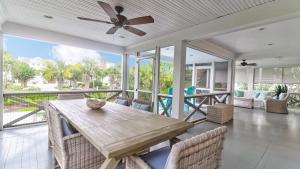 an open porch with a wooden table and chairs at 302 Charleston by AvantStay Stunning Private Pool in Mount Pleasant