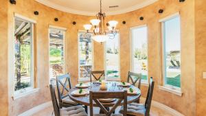 une salle à manger avec une table, des chaises et des fenêtres dans l'établissement Secluded Estate Exclusive Views of Wine Country Private Home Theater Twilight Vines by AvantStay, à Sage