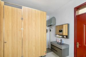 Un baño con lavabo y mueble de madera. en Qianxun Jushe B&B, en Kaifeng