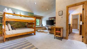 a bedroom with a bunk bed and a living room at Cherry Ridge by AvantStay Incredible Mountain Mansion w Game Room Hot Tub Views in Breckenridge