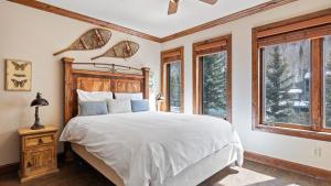 Un dormitorio con una cama grande y ventanas. en Ghostriders 11 by AvantStay Top Floor Condo w Large Patio Mountain Views, en Telluride