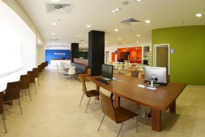 an office with a long table with a computer on it at One Xalapa Las Animas in Xalapa