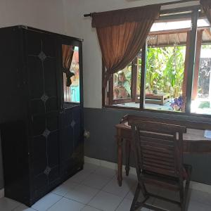 une pièce avec une table, une chaise et une fenêtre dans l'établissement Shalana Homestay- formerly Teka Teki House, à Seminyak