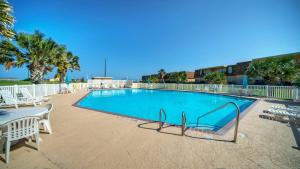una piscina con tavolo e sedie di 2 Pools Beach Boardwalk Access Studio Sleeps 5 Beach Bungalow by AvantStay a Port Aransas Altre 32 foto