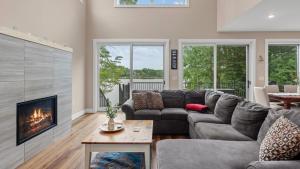 a living room with a couch and a fireplace at Lakeside Serenity by AvantStay Lakefront Newly Built Deck w Views in White Haven