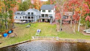an aerial view of a large house with a pond at Lakeside Serenity by AvantStay Lakefront Newly Built Deck w Views in White Haven