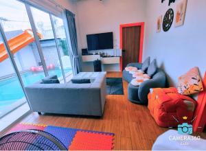 a living room with two couches and a television at The time's pool villa in Ban Bung