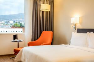 a hotel room with a bed and a chair and a window at Fiesta Inn Pachuca Gran Patio in Pachuca de Soto +35 photos