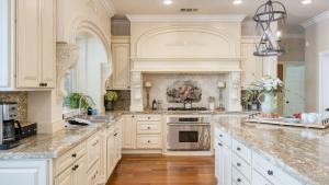 cocina grande con armarios blancos y encimeras de mármol en Grand Contento by AvantStay Extraordinary Estate w Pool Movie Room, en Temecula