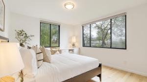 a white bedroom with a large bed and windows at Malvasia by AvantStay Luxe Wine Country Retreat in Santa Rosa +41 photos