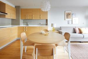 La Concha Suite 2 by FeelFree Rentals في سان سيباستيان: مطبخ وغرفة طعام مع طاولة وكراسي خشبية