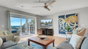 a living room with a couch and a table at Beachfront 3BDR Condo with Pool & Deck Ocean Views Ocean Blvd #102 by AvantStay in Isle of Palms