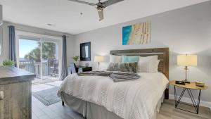 a bedroom with a large bed and a balcony at Beachfront 3BDR Condo with Pool & Deck Ocean Views Ocean Blvd #102 by AvantStay in Isle of Palms +31 photos