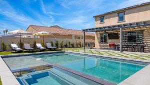 Desert Eden by AvantStay 6BR w Ensuite Backyard Oasis w Pool Hot Tub في كوتشيلا: حمام سباحة في الفناء الخلفي للمنزل