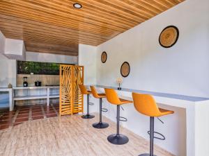 a kitchen with orange chairs and a counter at Koru Boutique Hostel Uvita in Uvita