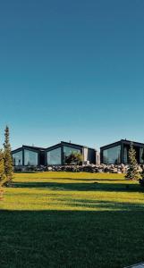 Un edificio con ventanas de vidrio en un campo de hierba. en HACIENDA & Królicza Nora, en Zatory 31 fotos más