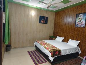 a bedroom with a large bed with wooden walls at Radha Madhav in Vrindāvan