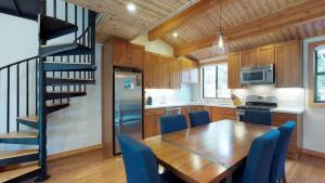 una cucina con un tavolo di legno e sedie blu di Sockeye by AvantStay Modern 2 BR Condo w Access to Northstar Resort Community a Kingswood Estates