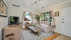 ein Wohnzimmer mit Sofa und Tisch in der Unterkunft Grapevine Cottage by AvantStay Hobby Vineyard Firepit in Glen Ellen