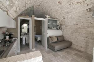 a kitchen with a couch and a chair in a room at Dimora Lumi in Locorotondo