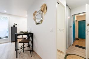 a room with a table and a chair and a hallway at Studio 27m² sur la Côte Pavée avec parking privé in Toulouse