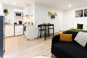 a living room with a couch and a kitchen at Studio 27m² sur la Côte Pavée avec parking privé in Toulouse +2 photos