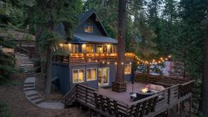 a house in the woods with lights on it at Washoe Way by AvantStay Luxury Tahoe Retreat A Location w Beach Access in Tahoe City