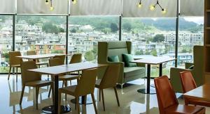 un ristorante con tavoli e sedie e una grande finestra di City Comfort Inn Liupanshui Sports Center a Shuicheng