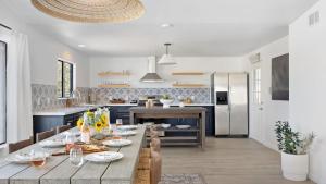 a kitchen and dining room with a wooden table with chairs at Carmella by AvantStay Modern JTree Home w Large Outdoor Area in Twentynine Palms